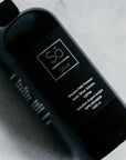 A 1000 ml black bottle of Só Silver Mission Fals Premium Ionic Silver Solution, photographed diagonally on a textured light gray surface.