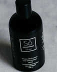 A black bottle of Só Silver Mission Falls Premium Ionic Silver Solution, 250 ml, shown on a light gray textured surface.