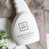 White spray bottle branded with 'Só Clean Stain Remover + Prewash' on a light marble background with light brown fabric and floral greenery.